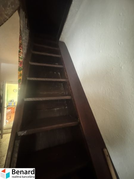 Eine Treppe, die in einem Einfamilienhaus nach oben führt, mit dunklen Holzstufen.