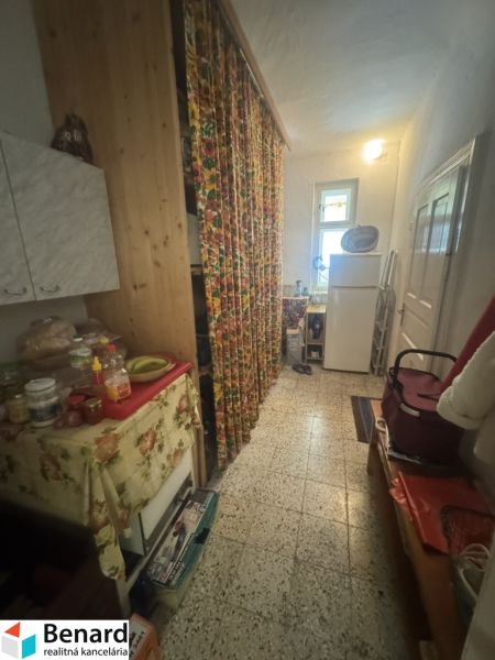 Der Flur in einem Einfamilienhaus mit bunten Vorhängen und Küchenmöbeln.