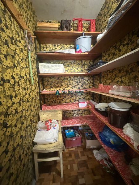 Abstellraum in einer 2-Zimmer-Wohnung mit Blumentapeten und Ablageböden.