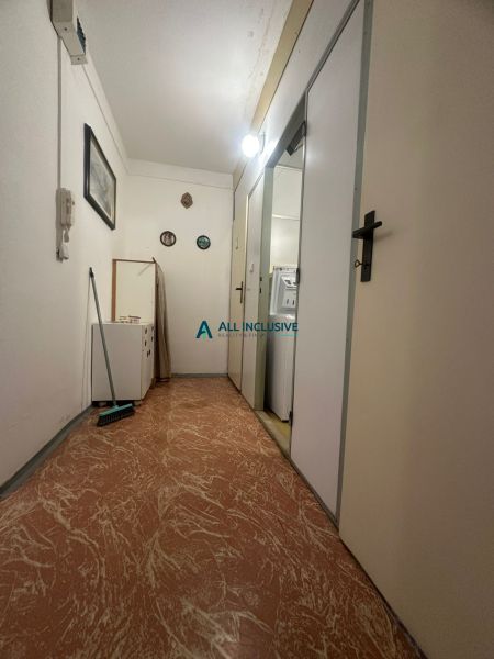 Der Flur in einer 2-Zimmer-Wohnung mit Holzboden, weißen Wänden und Licht.