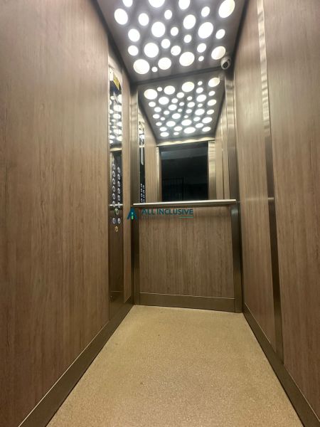 Der Innenraum des Aufzugs in einer 2-Zimmer-Wohnung mit Holzdekor an den Wänden.