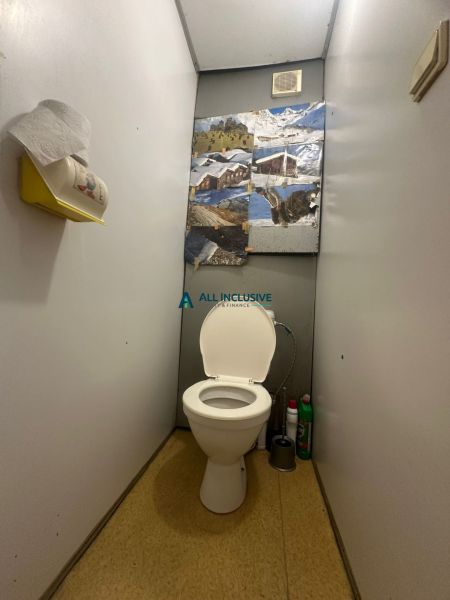 Toilette mit Wanddekoration und Stauraum in einer 2-Zimmer-Wohnung.
