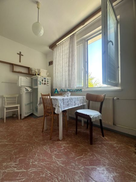 Esszimmer in einer 2-Zimmer-Wohnung mit Küchentisch, Kühlschrank und großem Fenster.