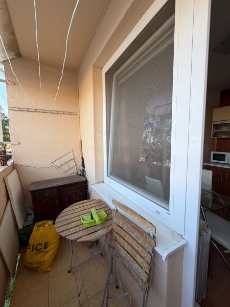 Balkon einer 3-Zimmer-Wohnung mit Holztisch und Stühlen, neben dem Küchenfenster.
