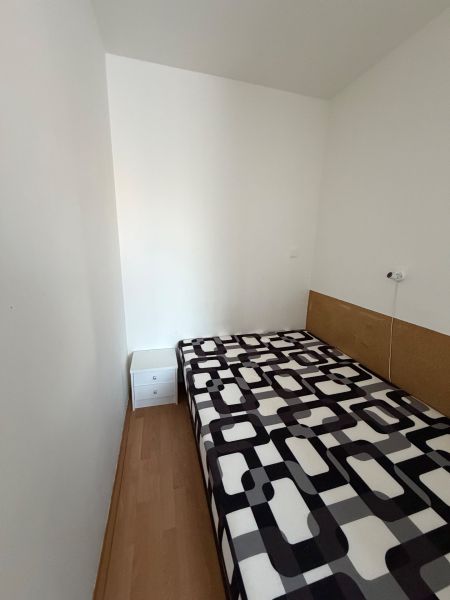Einfaches Zimmer in einer 3-Zimmer-Wohnung mit Bett und Boden in Holzoptik.