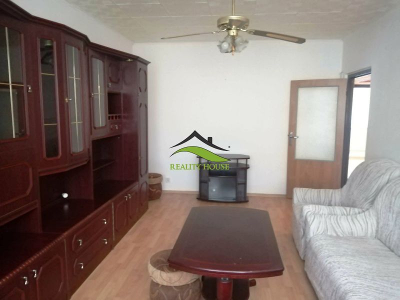 Wohnzimmer mit Holzboden, Schrank und Sofa in einer 3-Zimmer-Wohnung.