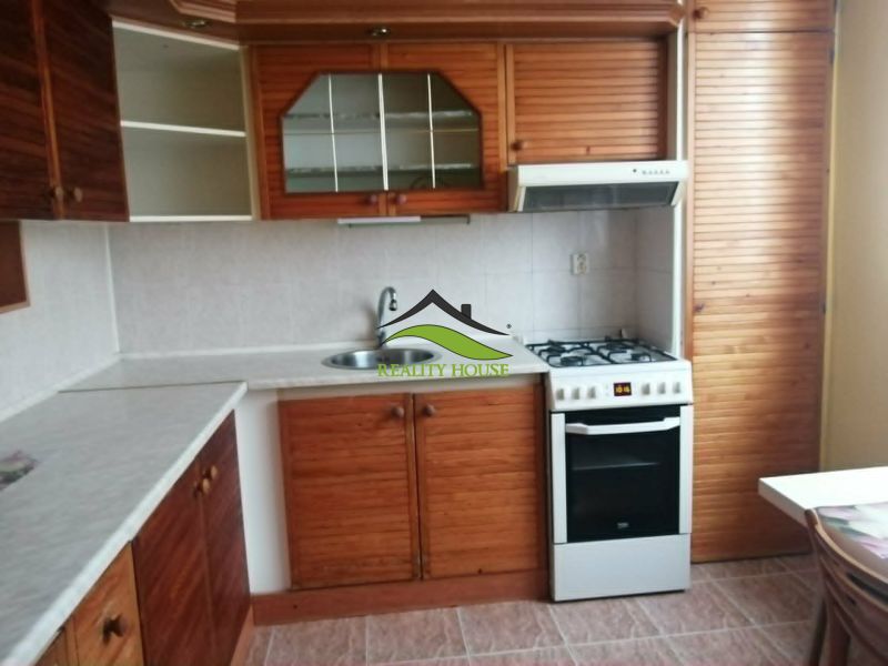 Küche in einer 3-Zimmer-Wohnung mit einer Küchenzeile in Holzdekor.