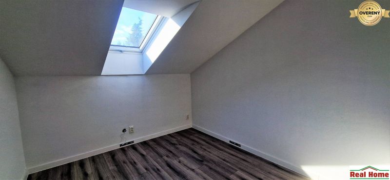Dachzimmer mit großem Dachfenster und Holzboden in einem Einfamilienhaus.