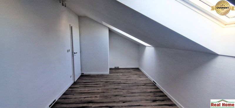 Dachboden in einem Einfamilienhaus mit Holzboden und Dachfenster.