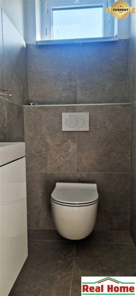 Toilette mit Keramikfliesen in einem Einfamilienhaus.