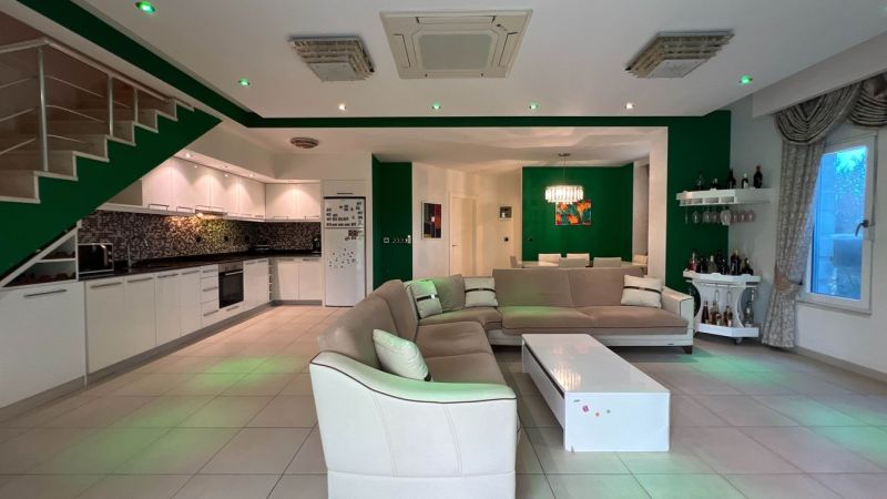 Wohnzimmer mit Sofa, Küche, Esszimmer und weißen Möbeln in einer besonderen Immobilie.