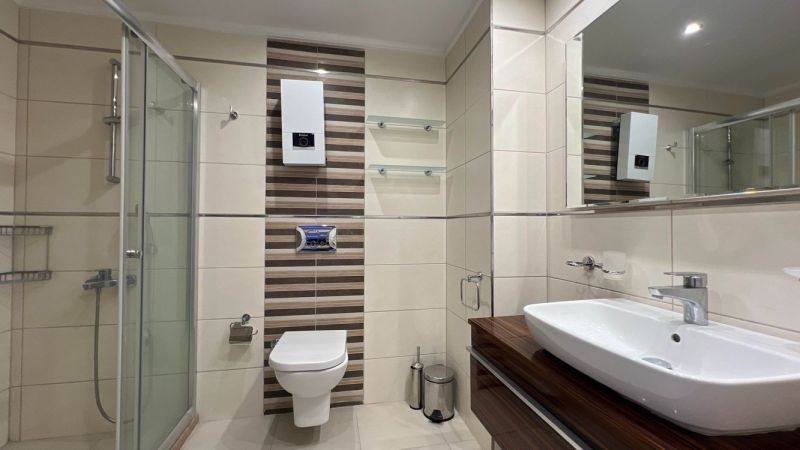 Badezimmer mit Dusche, Waschbecken und Toilette, Besondere Immobilien.