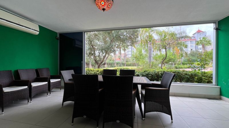 Besondere Immobilien mit Terrasse, Rattanmöbeln und Blick auf den Garten.