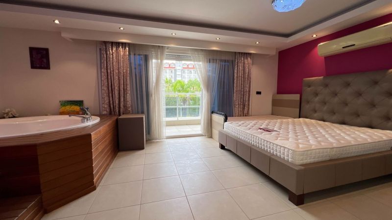 Ein Schlafzimmer mit eingebautem Whirlpool, Bett und Balkon, Ungewöhnliche Immobilien.