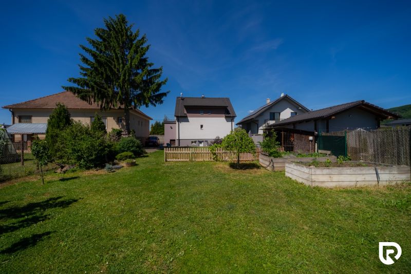 Der Garten des Einfamilienhauses in der Jahodová-Straße in Trenčín mit Rasen und Bäumen.