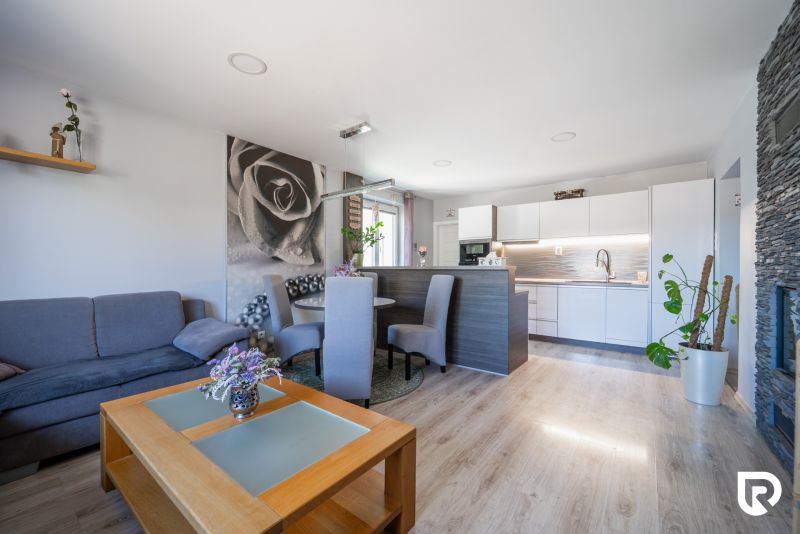 Wohnzimmer in einem Einfamilienhaus mit Küche und Holzboden.