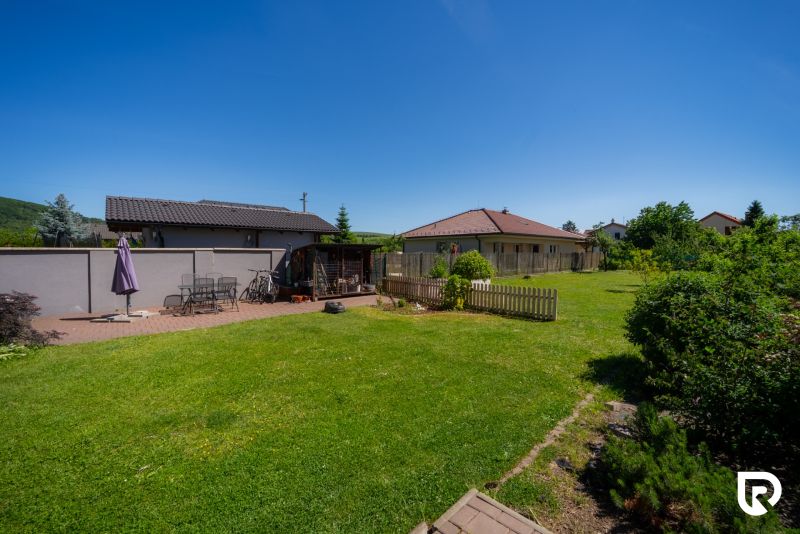 Garten bei einem Einfamilienhaus in der Jahodová-Straße in Trenčín mit Sitzgelegenheit und Rasen.