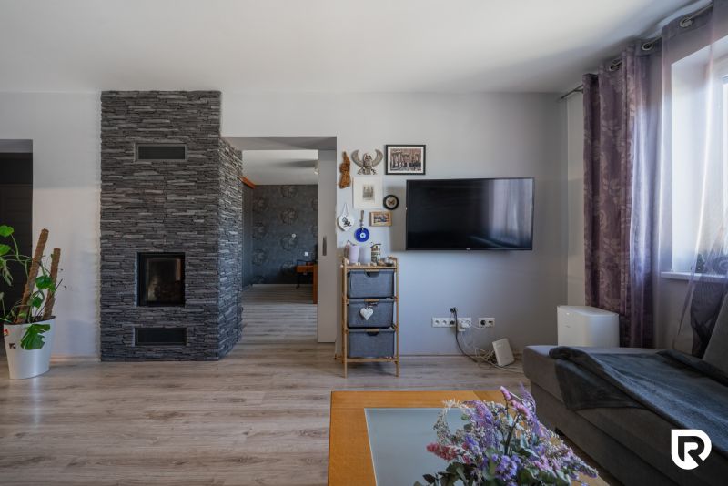 Innenraum eines Einfamilienhauses mit Fernseher, Dekorationen und Holzboden.