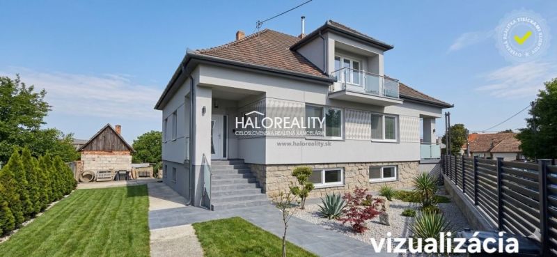 Ein Einfamilienhaus in Dolné Saliby mit einem gepflegten Garten und einem Steinsockel.