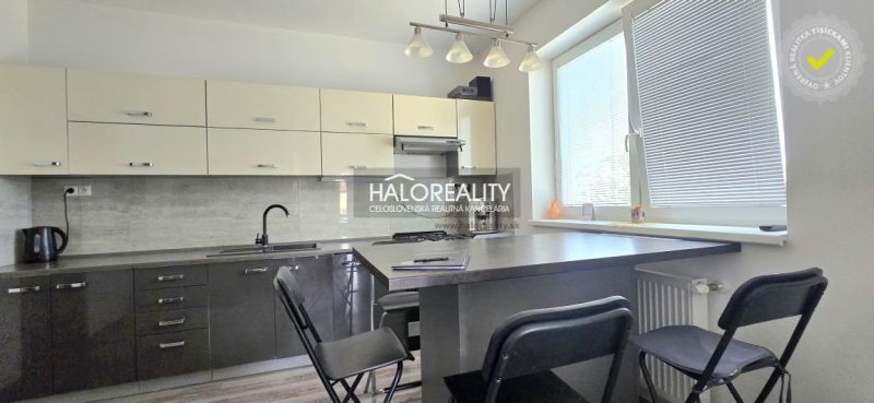 Eine Küche in einem Einfamilienhaus mit dunklen Schränken und einem Boden in Holzoptik.