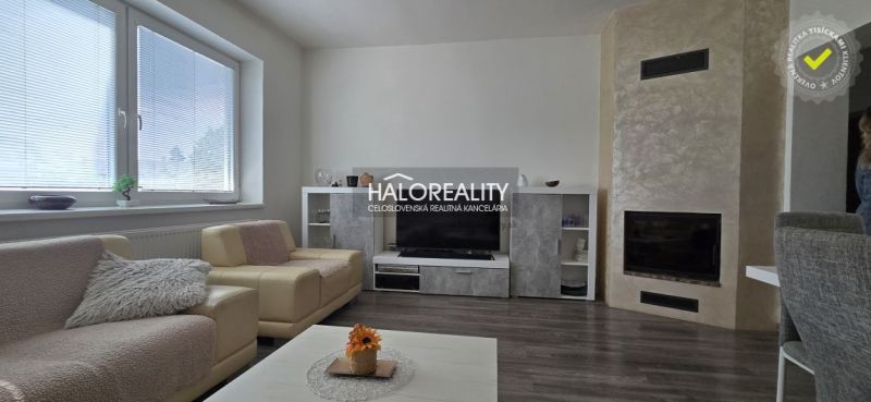 Wohnzimmer mit Kamin, Holzboden und bequemen Sofas in einem Einfamilienhaus.