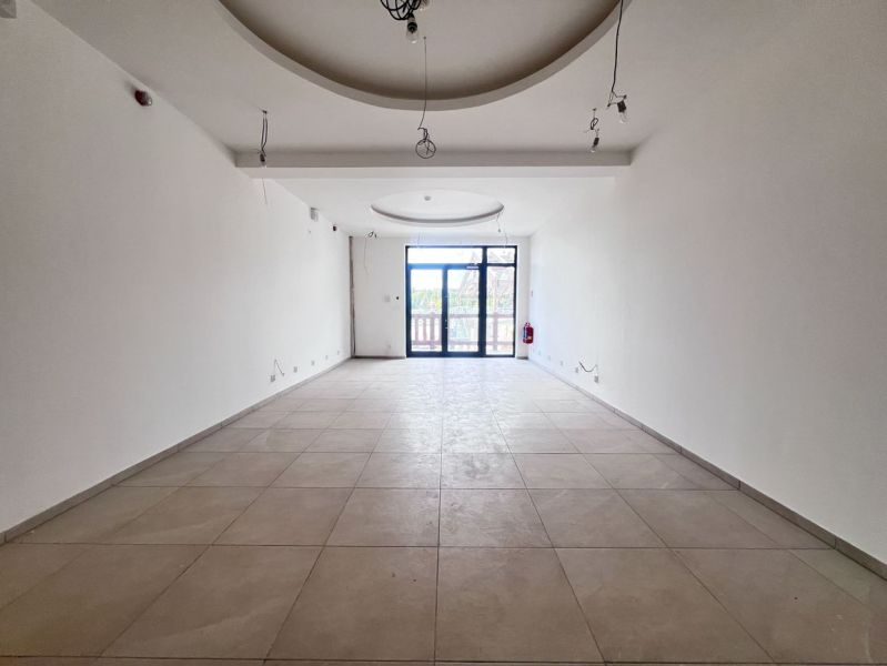 Interieur eines Geschäftslokals mit Fenster und weißen Wänden.