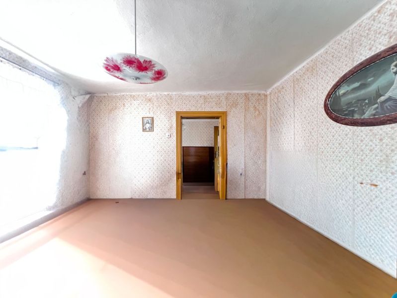 Ein Raum in einem Einfamilienhaus mit einem dekorierten Kronleuchter und einem Blumenmuster an der Wand.