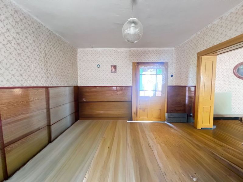 Innenraum eines Einfamilienhauses mit Holztüren, Holzverkleidung und einem Boden mit Holzdekor.