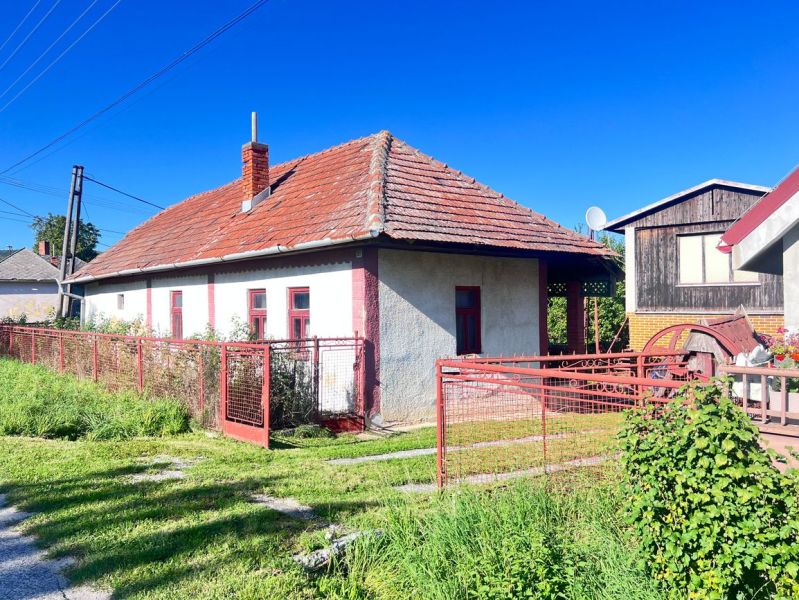 Ein Einfamilienhaus in Žirany, Bezirk Nitra, mit rotem Dach und Zaun.