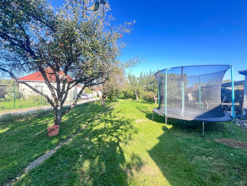 Garten in Žirany, Bezirk Nitra, Region Nitra mit Obstbaum und Trampolin bei einem Einfamilienhaus.