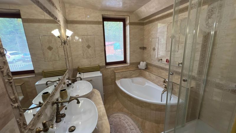 Badezimmer in der Villa mit Badewanne, Dusche und Doppelwaschbecken.