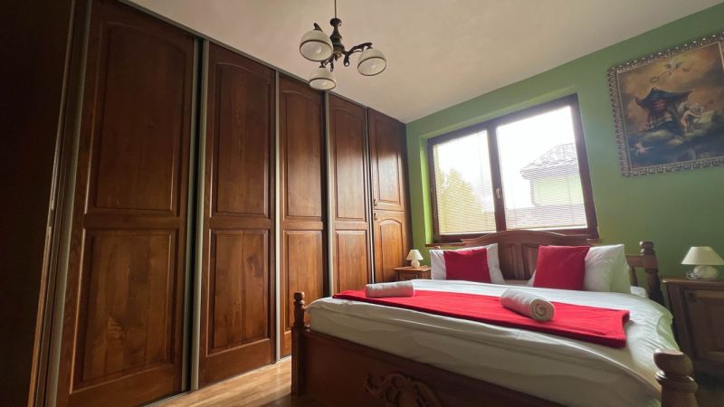 Schlafzimmer in der Villa mit großem Schrank, Bett, Bild und Holzdekor.