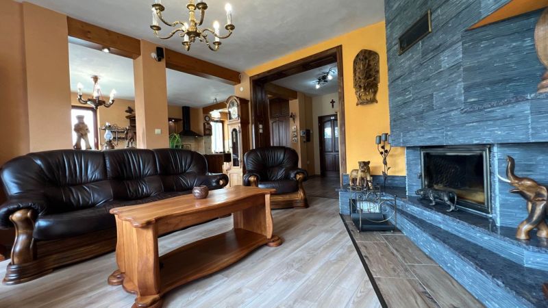 Ledersofa und Kamin, Boden mit Holzdekor, elegantes Interieur der Villa.