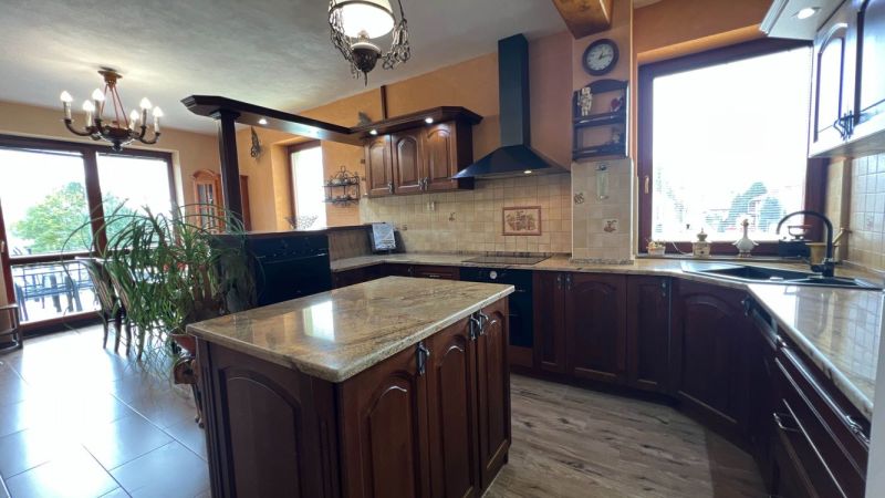 Die Küche der Villa mit Holztönen, Boden mit Holzdekor, geräumige Fenster.