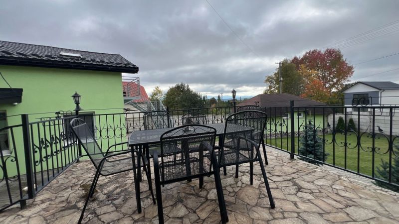 Terrasse der Villa in Štôla, Bezirk Poprad, Region Prešov, mit einem Tisch und Metallstühlen.