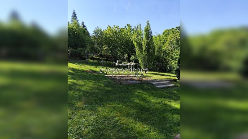 Garten bei einem Einfamilienhaus in Horné Otrokovce, grüner Rasen und Obstbäume.