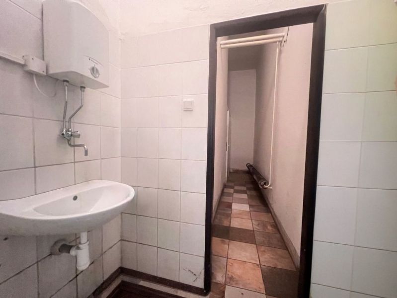 Badezimmerinterieur in Lagerhallen mit Waschbecken und Wandwassererhitzer.