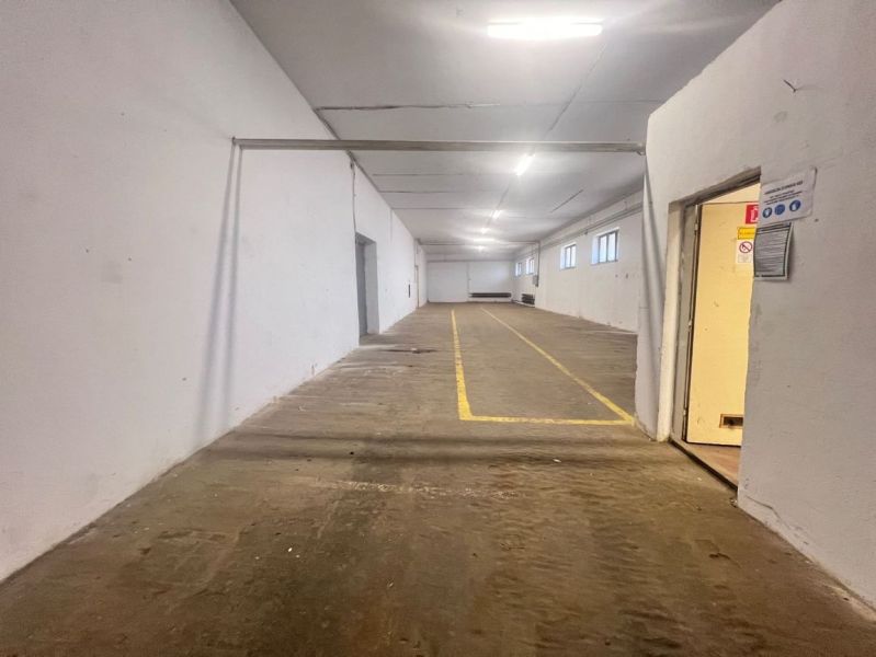 Innenräume von Lagern und Hallen mit gelben Linien auf dem Boden, weißen Wänden, energiesparender Beleuchtung.