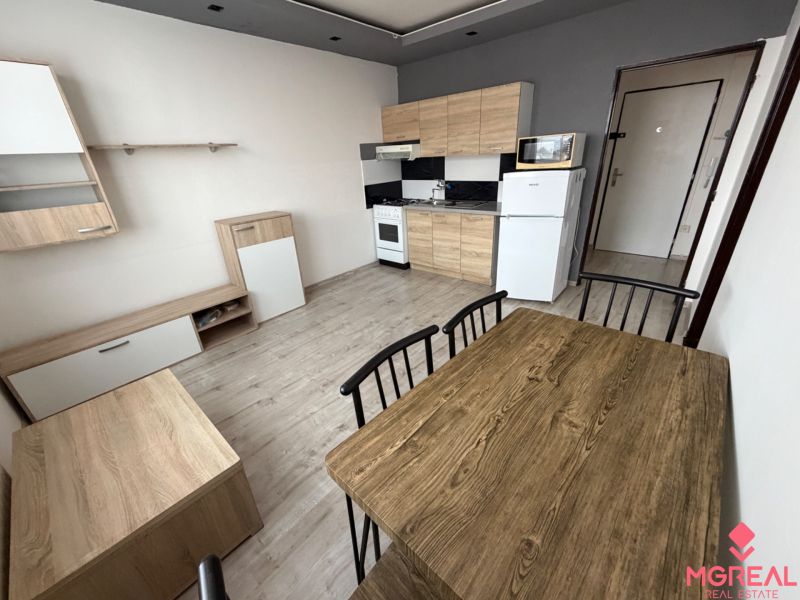 Küche und Essbereich mit Holzdekorboden in einer Einzimmerwohnung.