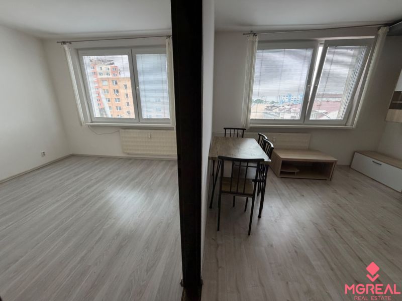 Innenraum einer 1-Zimmer-Wohnung mit Holzboden und Tisch.