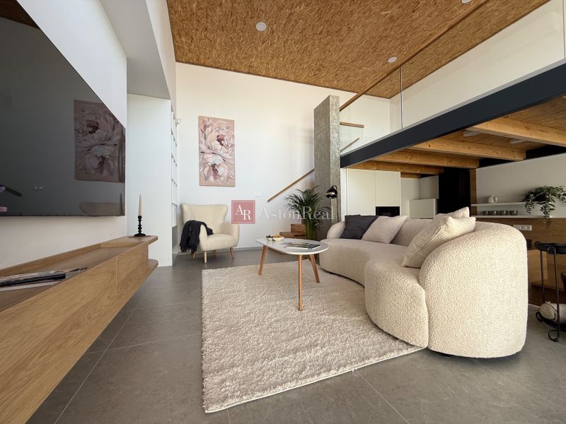 Wohnzimmer in einem Einfamilienhaus mit bequemer Couch und dekorativen Bildern an der Wand.