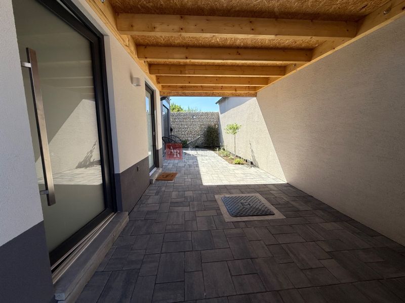 Ein Einfamilienhaus in Piešťany am Orviský kút mit einer eingelassenen Terrasse und Pflastersteinen.
