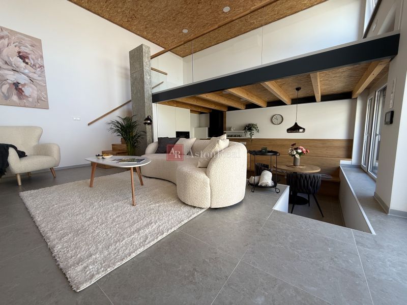 Wohnzimmer in einem Einfamilienhaus mit bequemen Möbeln und Wanddekoration.