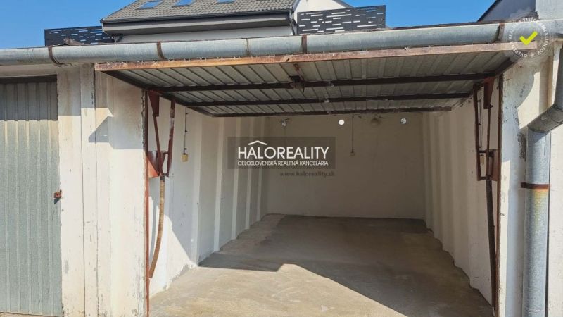 Eine leere Garage in Senec mit Überdachung und weißen Wänden.