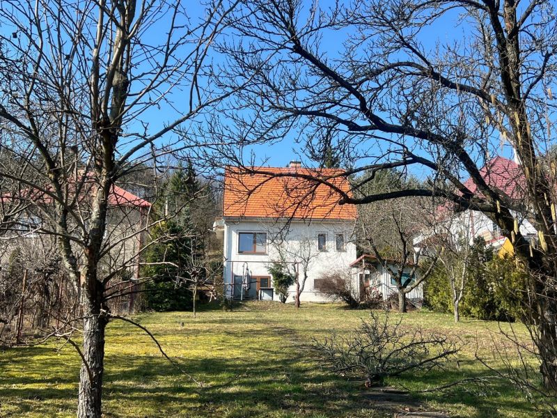 Ein Einfamilienhaus in Podhájska, Kráľová, umgeben von Bäumen und Rasen, mit einem orangefarbenen Dach.