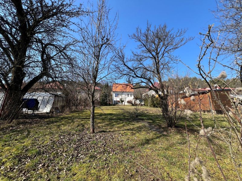 Ein Garten im Bezirk Banská Bystrica rund um ein Einfamilienhaus mit Rasen und Bäumen.
