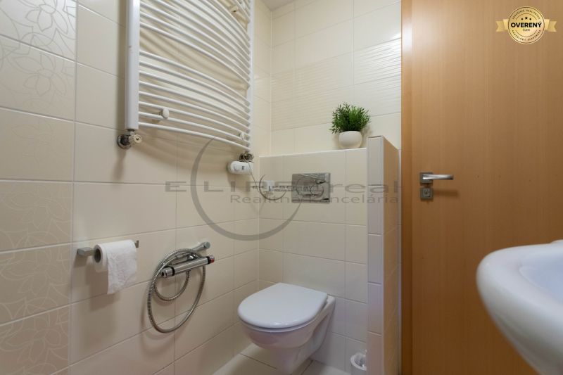 Badezimmer mit Keramikfliesen, Toilette und Heizkörper in einem Einfamilienhaus.