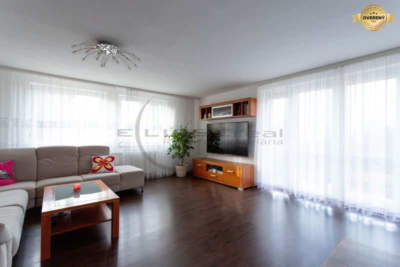 Wohnzimmer in einem Einfamilienhaus mit Holzboden und großen Fenstern.