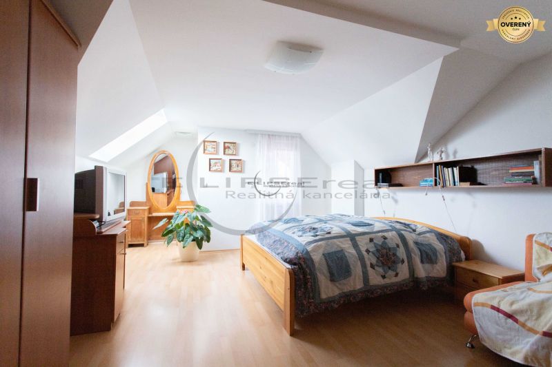 Schlafzimmer in einem Einfamilienhaus mit Holzboden, Bett und Dekorationen.