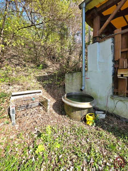 Holzkonstruktion der Hütte und Regentonne im Garten in der Straße 1. mája, Krásna.